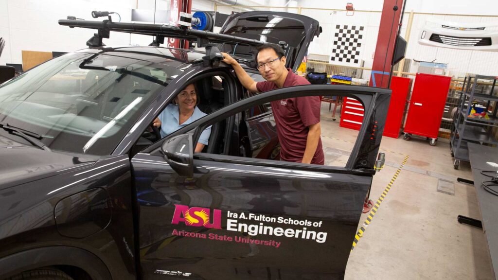 Norma Faris Hubele examines an automobile used by researchers at the Battery Intelligent and Electric Vehicle Laboratory