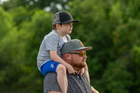 Father and son listen as speakers talk about the history of the Mason Rudolph golf course at the Save Mason Rudolph Golf Rally. May 31, 2024 (Jeff Danault)