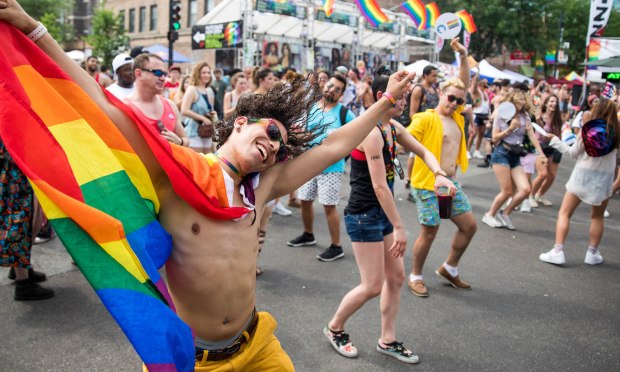 Festivus Jose Ojeda dances with a rainbow flag around his neck during the Chicago Pride Fest on June 17, 2018, in Chicago.  (Courtney Pedroza/Chicago Tribune)