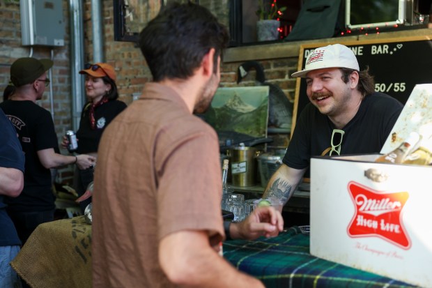 General Manager DJ Dodd talks to a customer during a Sunday BBQ on the Sportsman's Club patio in Ukrainian Village on June 2, 2024. (Eileen T. Meslar/Chicago Tribune)